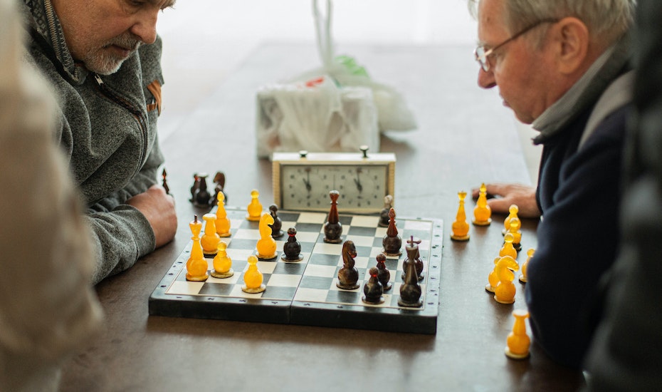 señores practicando ajedrez en sus tiempos libres